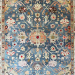 Elegant blue floral hand-knotted area rug featuring intricate patterns and vibrant colors, showcasing a detailed central medallion surrounded by ornate floral motifs on a blue background.