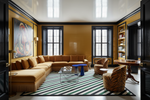 Modern living room with a sectional sofa, striped rug, and decorative elements.