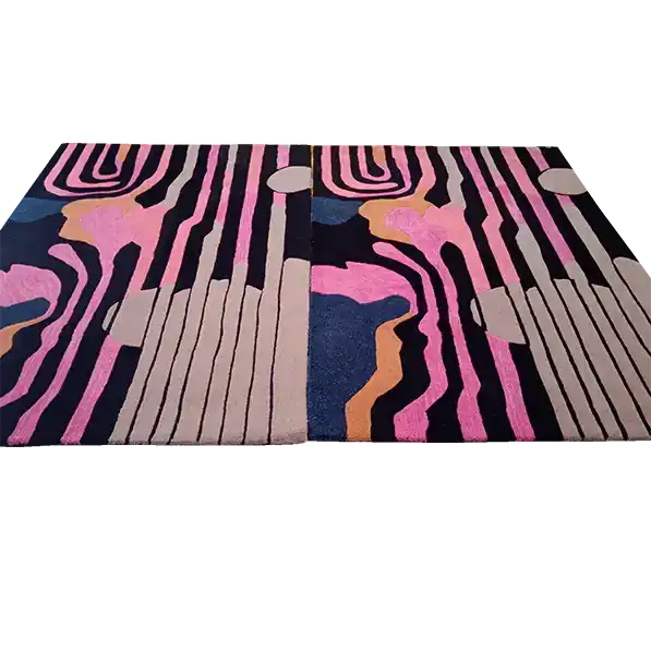 This is a close-up view of the Evolving Shapes Hand Tufted Rug, showcasing its striking abstract design in vibrant pink, blue, beige, and black. Perfect for adding a contemporary touch to your living room or dining room, this wool area rug stands out with its artistic patterns, making it an ideal choice for those seeking unique rugs for living room and dining room spaces.