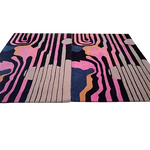 This is a close-up view of the Evolving Shapes Hand Tufted Rug, showcasing its striking abstract design in vibrant pink, blue, beige, and black. Perfect for adding a contemporary touch to your living room or dining room, this wool area rug stands out with its artistic patterns, making it an ideal choice for those seeking unique rugs for living room and dining room spaces.