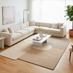 Modern living room with a beige sectional sofa, marble coffee table, beige rug, and decorative items.