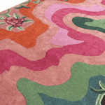 Close-up of a colorful patterned rug with pink, green, and orange colors.