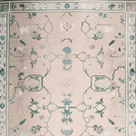 Gilded Serenity Hand Tufted Area Rug featuring an intricate vintage design with floral patterns in soft pink and green hues. This elegant wool rug is perfect for adding a touch of sophistication to any living room.