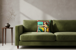 A square throw pillow featuring a retro-style illustration of a woman in a yellow dress leaning against a teal and red vehicle, styled on a white slipcovered sofa against a textured beige wall.