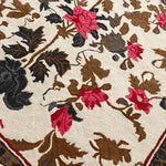 Close-up view of the Golden Glory Square Hand Tufted Wool Rug, showcasing its intricate floral design in vibrant red, brown, and black hues. Perfect as a large living room rug or a cozy addition to your bedroom, this square area rug adds elegance and warmth to any space.