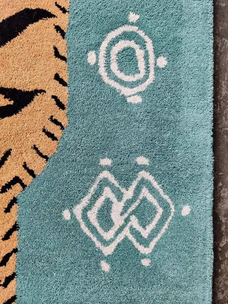 Close-up view of a Green Oriental Tiger Hand Tufted Wool Rug, showcasing its intricate abstract tiger pattern and geometric designs. Perfect for adding a touch of elegance to your living room, this large area rug is crafted from high-quality wool, making it an ideal choice for those seeking stylish and durable rugs for living room spaces.