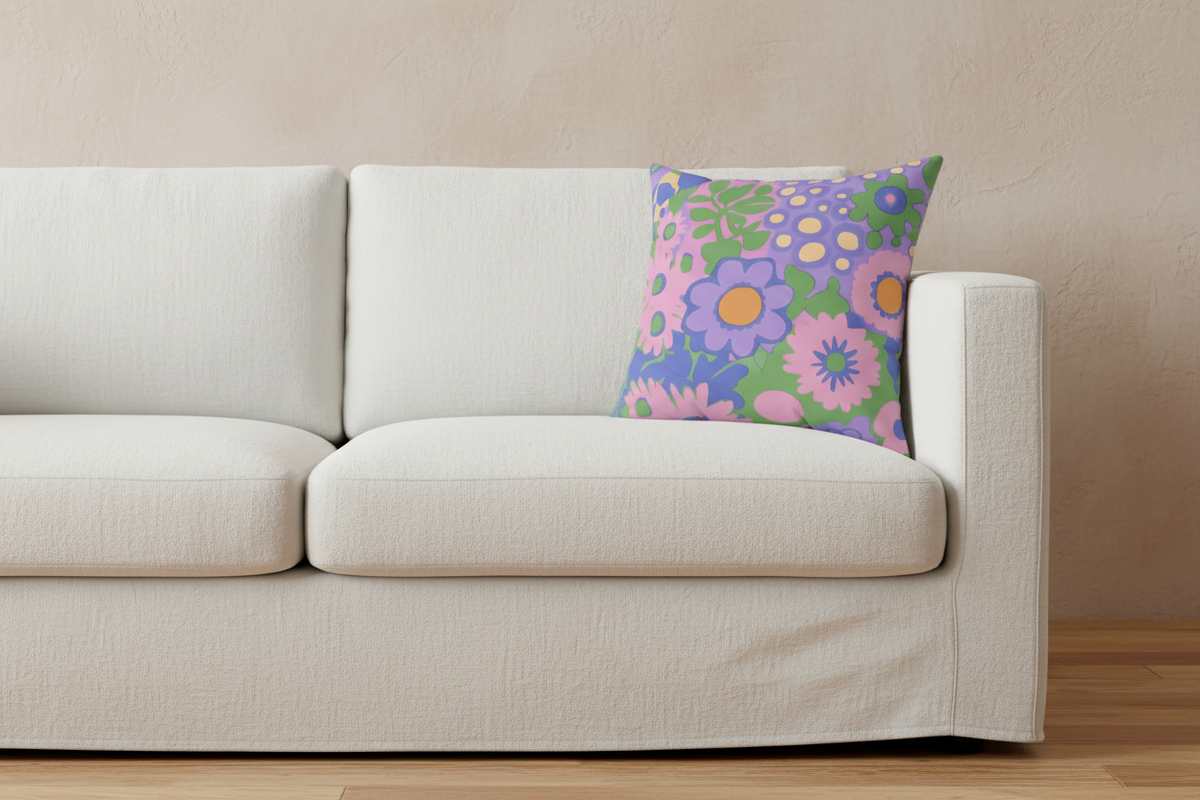 A white fabric slipcovered sofa with a colorful floral throw pillow, set against a textured beige wall and light wood floor.
