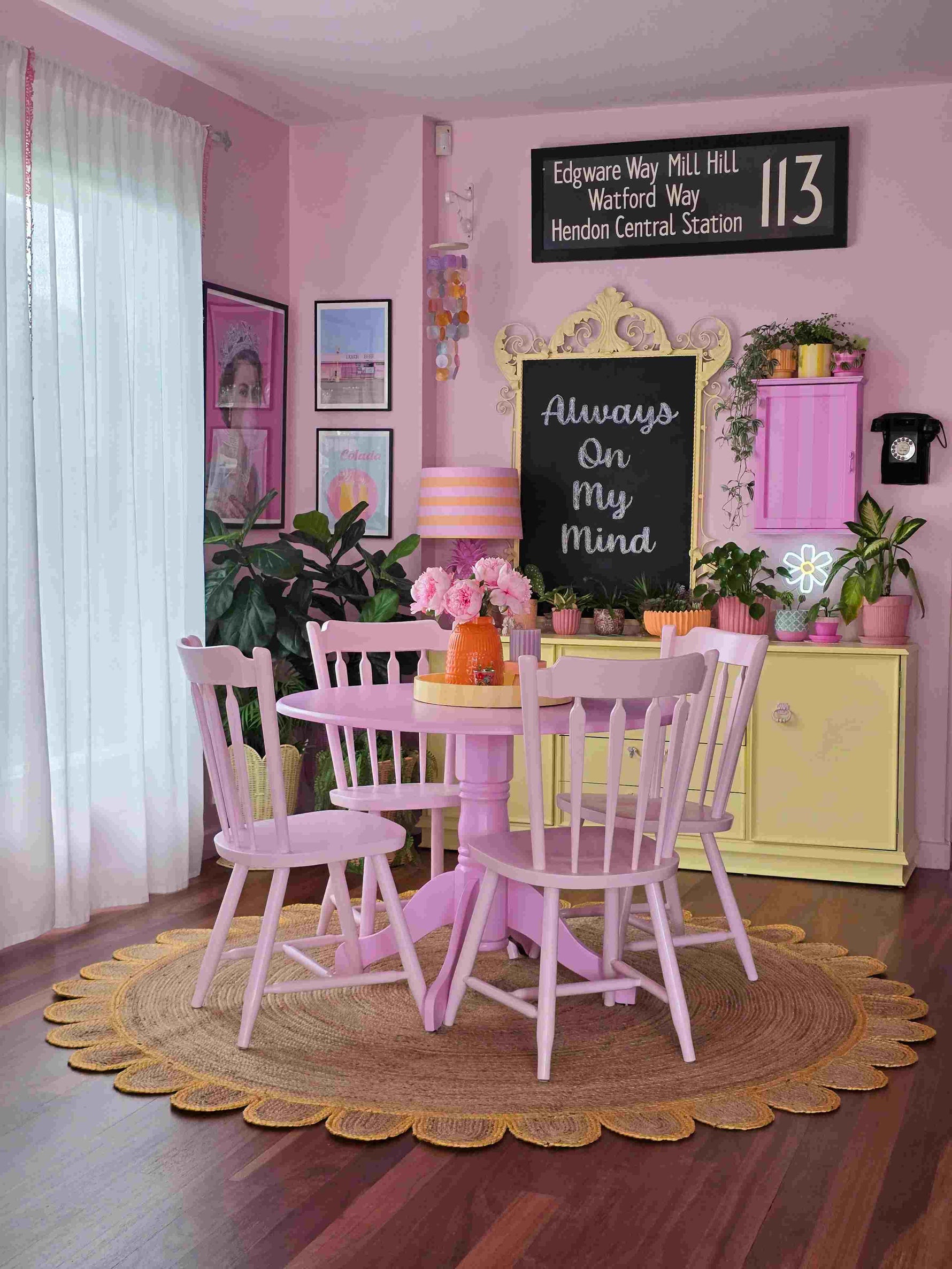 A cozy living room featuring a handmade yellow scalloped round jute area rug, perfectly complementing a pastel pink dining set. This area rug adds warmth and texture to the space, ideal for those seeking stylish area rugs for living room decor.