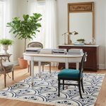 Dining room with a white table, art deco rug, chairs, and decorative elements.
