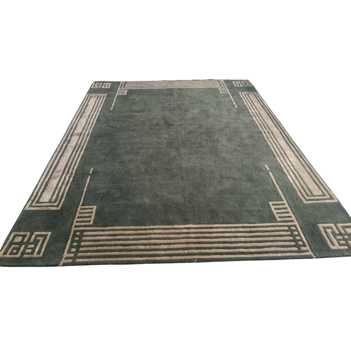 Green rug with beige border design on a white background
