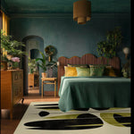 Stylish area rug in a cozy office setting, featuring an abstract design with black and olive shapes on a wool surface. Ideal for large office spaces, this rug enhances the room with its modern aesthetic and complements the wooden furniture and lush green plants.