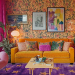 Vibrant living room featuring an Arabian Nights hand tufted area rug with a starry pattern, enhancing the colorful decor. The wool rug complements the mustard yellow sofa adorned with eclectic pillows, surrounded by artistic walls. Ideal for those seeking unique living room area rugs or adding a touch of whimsy to a bedroom.