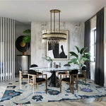 A stylish living room featuring the Azure Blossom Wave Hand Tufted Area Rug. The wool rug showcases a vibrant, abstract design with waves of blue and floral patterns, perfectly complementing the modern decor. Ideal for adding a touch of elegance to your office or living space.