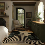 A stylish black and gold striped hand-tufted area rug in a cozy living room setting. The wool rug enhances the ambiance of the space, making it perfect for both living room and dining room areas. This abstract design serves as an elegant dining table rug, blending seamlessly with the rustic decor of the room.