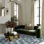 Stylish living room featuring a Blue and Black Leopard Print Hand Tufted Wool Rug. This large area rug adds a touch of elegance to the space, complementing the modern green sofa and sleek coffee table. Ideal for bedrooms or large living rooms, this wool rug combines bold patterns with comfort.