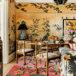 Vibrant Blushing Birds Garden Hand Tufted Area Rug in a cozy room. Perfect for bedrooms and offices, this wool rug features intricate floral designs on a warm background, adding an elegant touch to any space.