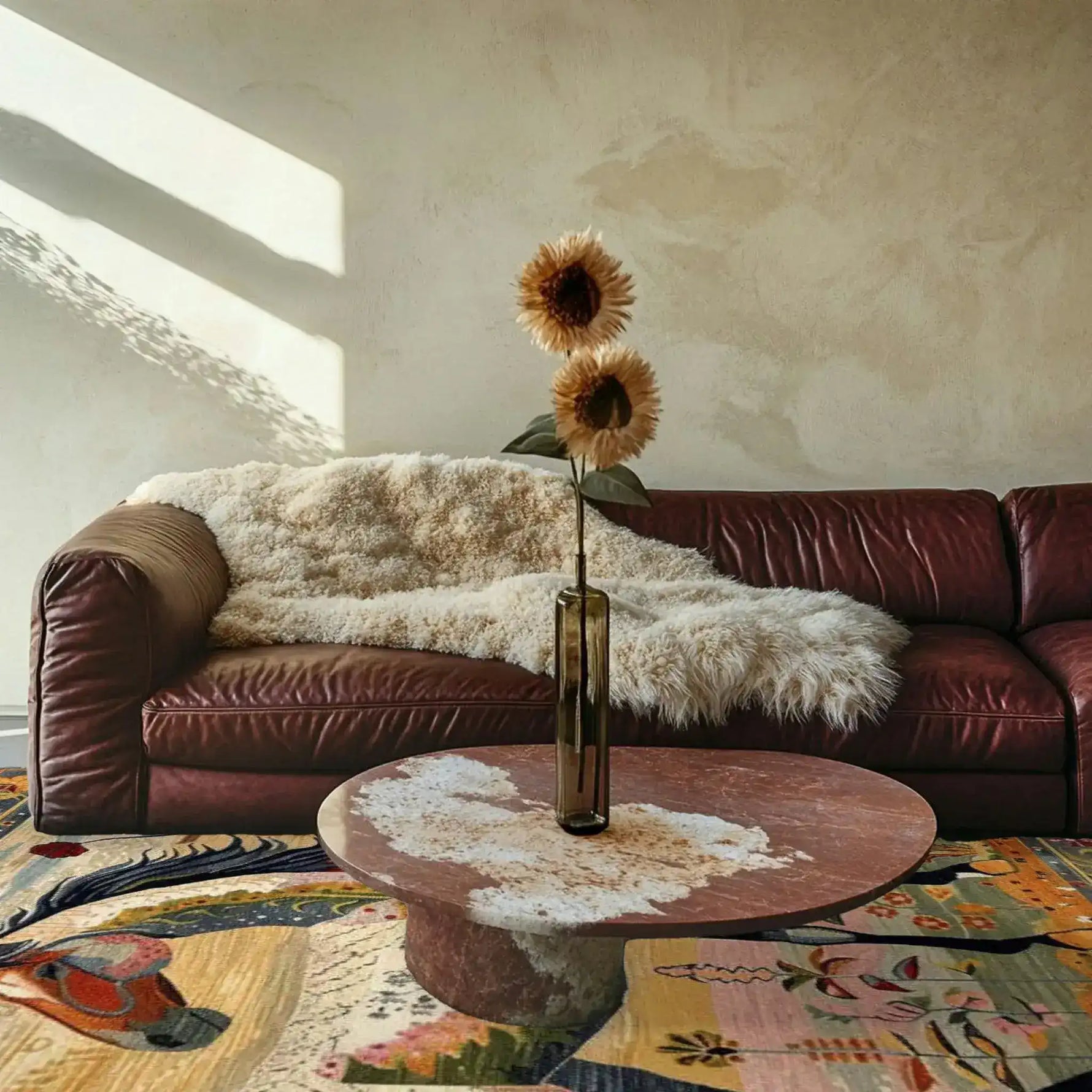 A cozy living room featuring a Bright Meadow Steed Hand Knotted Area Rug with a vibrant abstract design. This large square area rug adds a touch of elegance to the space, complemented by a plush leather sofa and a round coffee table. Perfect for those seeking a Persian-style wool rug for their living room.