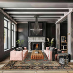 Luxurious living room with pink sofas, gray floral persian rug, a fireplace, and decorative elements.