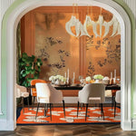 This luxurious living room features a vibrant 'Chasing Butterflies' hand-tufted area rug, perfect for adding a pop of color and style. The wool rug, with its intricate butterfly design, complements the elegant dining setup, making it an ideal choice for living room area rugs. The room's sophisticated decor, with a stylish chandelier and floral wall accents, enhances the inviting ambiance.