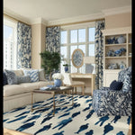 Elegant living room featuring a Cityscape Crowd Hand Tufted Area Rug in a sophisticated design. The wool rug complements the formal dining room aesthetic with a stylish pattern, seamlessly integrating with the decor of the dining table and living room. The space is warmly lit with natural light from large windows, enhancing the room's inviting atmosphere.