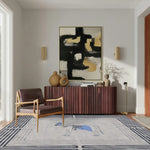 A stylish office setting featuring the Classic Horse Silver Maze hand-tufted area rug. The wool rug is elegantly placed in a room with a modern armchair, a sleek sideboard, and contemporary artwork, perfect for living room and dining room settings.