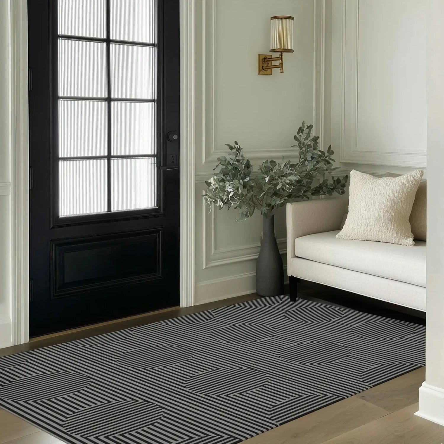 A stylish Contemporary Eclipse Illusion Hand Tufted Wool Rug displayed in a modern entryway. The area rug features a bold geometric pattern, perfect for enhancing the aesthetics of a living room or office. Its monochrome design complements the elegant decor, including a beige sofa and greenery, making it an ideal choice for those seeking quality wool rugs for living spaces.