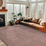 A stylish living room featuring a Contemporary Eclipse Illusion Hand Tufted Wool Rug in red. This large area rug, perfect for living room settings, showcases an eye-catching geometric pattern, complementing the cozy leather sofa and modern decor. Ideal for those seeking trendy wool rugs to enhance their living space.