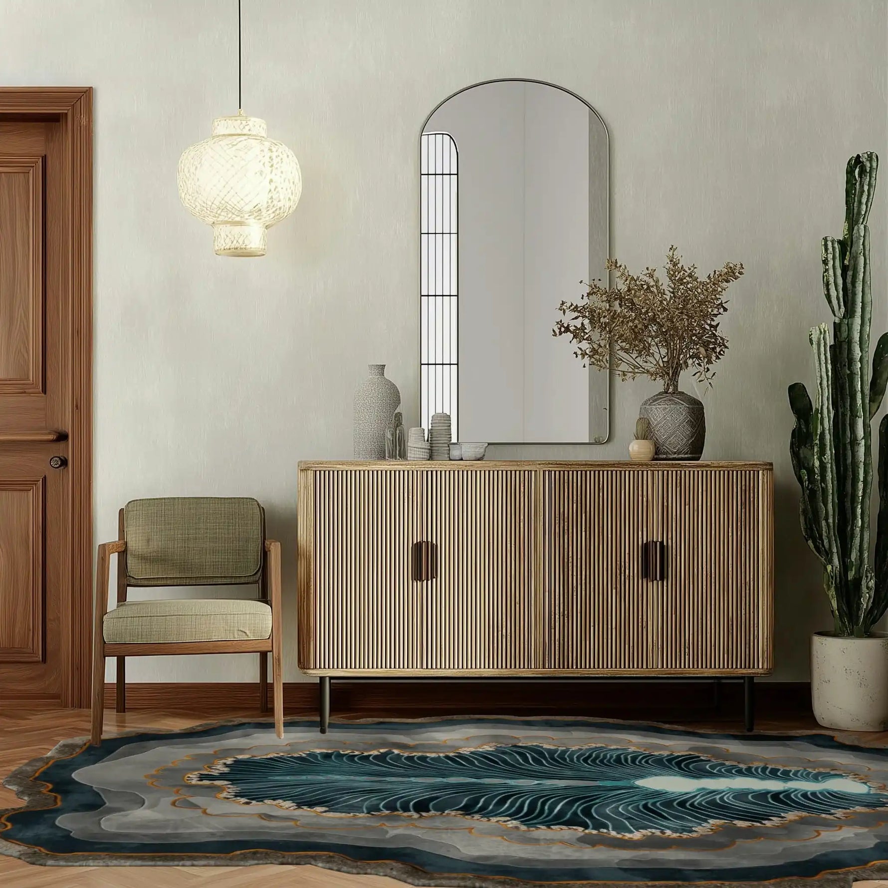 Stylish living room featuring the Crystal Depths Hand Tufted Viscose Area Rug with abstract, swirling patterns in blue and grey, placed on wooden flooring. The room is elegantly decorated with a modern wooden sideboard, a comfortable chair, and a hanging light fixture, creating a cozy and inviting atmosphere.