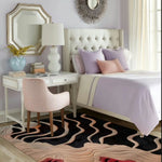 A contemporary curved line hand tufted area rug in a stylish living room setting. The wool rug features an abstract design with flowing lines in black and beige, adding elegance to the room. This area rug perfectly complements the modern decor, making it an ideal choice for living room area rugs.