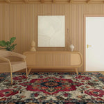 A beautifully styled living room featuring the Eternal Weave Hand-Tufted Area Rug. This Persian-inspired wool rug in an 8x10 size adds a touch of elegance with its intricate red and navy floral patterns. Perfect for dining or living room spaces, it complements the neutral-toned decor and wooden furniture seamlessly.