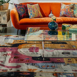 Ethereal Mask Tapestry Hand Knotted Rug featuring a vibrant abstract design in pinks, blues, and oranges. This contemporary area rug is perfect for adding a vintage touch to your bedroom or office. The wool rug is showcased under a modern glass coffee table, complemented by a bright orange sofa with colorful pillows, creating a cozy and stylish space.