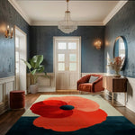 A beautifully decorated living room features a large, contemporary floral rug made of hand-tufted wool. The vibrant design of the area rug, featuring a bold red flower, adds a modern touch to the space. Perfect for large living rooms, this wool rug complements the elegant decor with its unique style, becoming a focal point in the room.