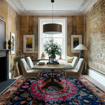 A vibrant floral rug adds a splash of color to a stylish dining room setup. This area rug, perfect for both living rooms and formal dining rooms, features intricate floral patterns, enhancing the boho and elegant vibe of the space. Made from quality wool, it complements the sophisticated decor and furniture arrangement, making it a standout piece in the room.