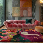 Luxurious wool hand-knotted area rug with vibrant floral and abstract patterns, perfect for adding elegance to a bedroom or living room setting. The colorful design complements the plush pink sofa, creating a serene and stylish atmosphere.