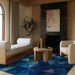 A contemporary living room featuring a stunning Geometric Getaway Hand Tufted Wool Rug with a blue abstract pattern. The area rug complements the wooden furniture and neutral tones, making it an ideal choice for living rooms, kitchens, or as a hallway runner rug.