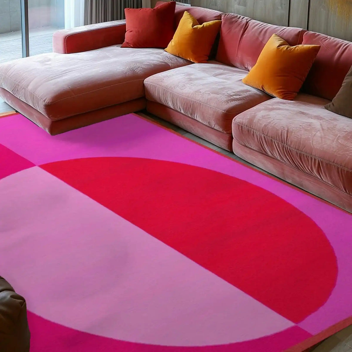 A stunning minimalist geometric area rug in pink hues lies elegantly on the floor of a modern living room. The hand-tufted wool rug features bold geometric patterns, adding a vintage flair to the space. Perfect for an 8x10 living room setup, the rug complements the cozy blush sofa adorned with colorful throw pillows.