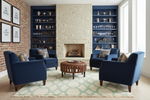 Modern living room with blue armchairs, green and beige rug, a fireplace, and bookshelves.