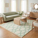 Modern living room with a green sofa, wooden coffee table, and patterned green knotted rug.