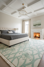 Modern bedroom with a bed, rug, and fireplace.