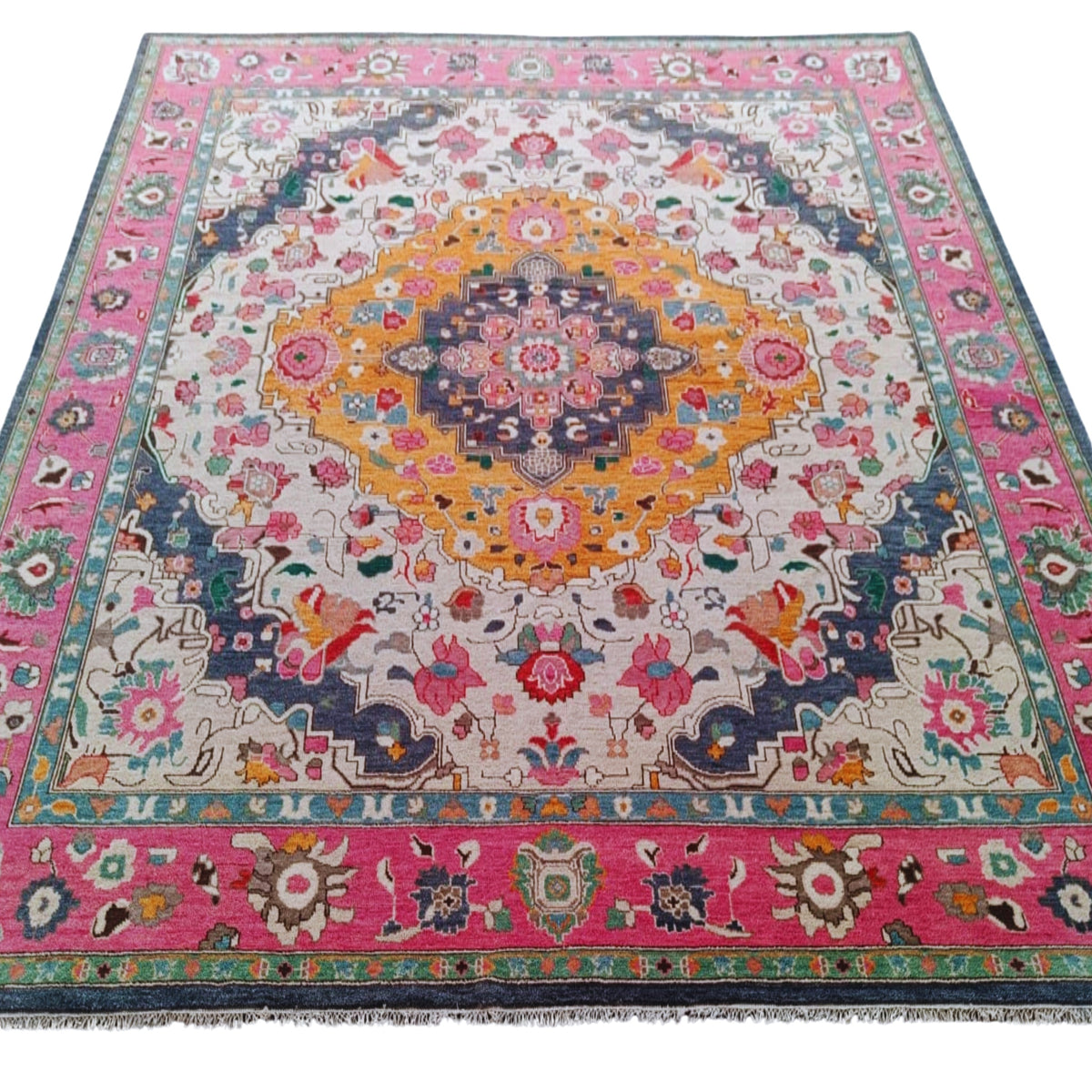 Colorful floral and geometric patterned rug with pink border on a white background