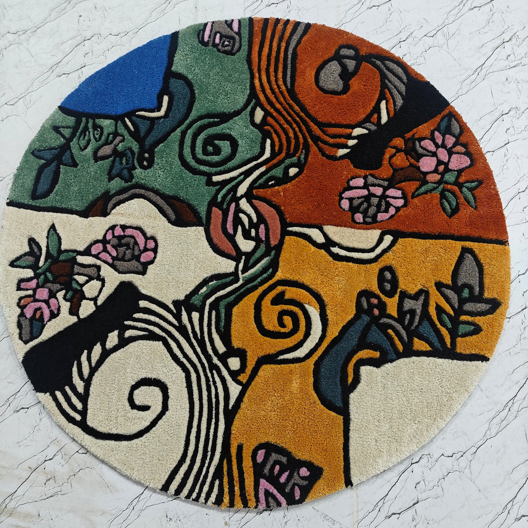 Round tufted rug with artistic design on a textured white surface. Nature's Kaleidoscope Hand Tufted Round Rug