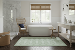 Modern bathroom with freestanding bathtub, green rug, and window