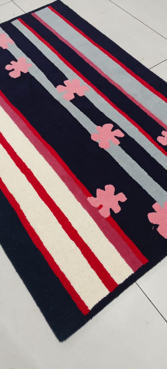 Striped rug with pink flower patterns on a white floor