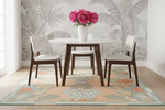 Dining room with a round table and chairs, floral rug, and wall with leaf pattern.
