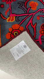 Floral-patterned rug with brand care tag on top