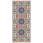 A rectangular area rug with a traditional floral pattern in  blue, green, and cream, shown flat against a PINK background.