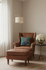 A square throw pillow with a colorful zebra print on a teal and blue background, styled on a light wood armchair in a modern living room setting.
