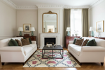Luxurious living room with a pink butterfly rug, white sofas, decorative pillows, and a coffee table.