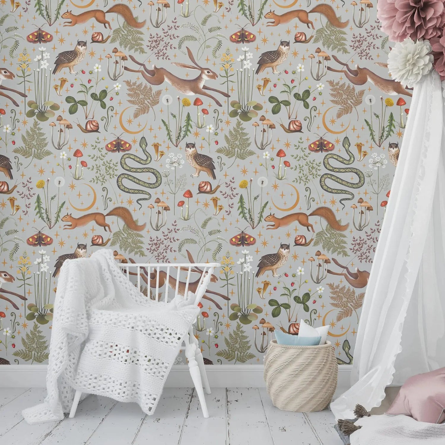 Children's room with patterned wallpaper featuring animals and plants, white crib, and white canopy bed.