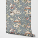 Roll of wallpaper with nature-themed design featuring animals and plants on a blue background.